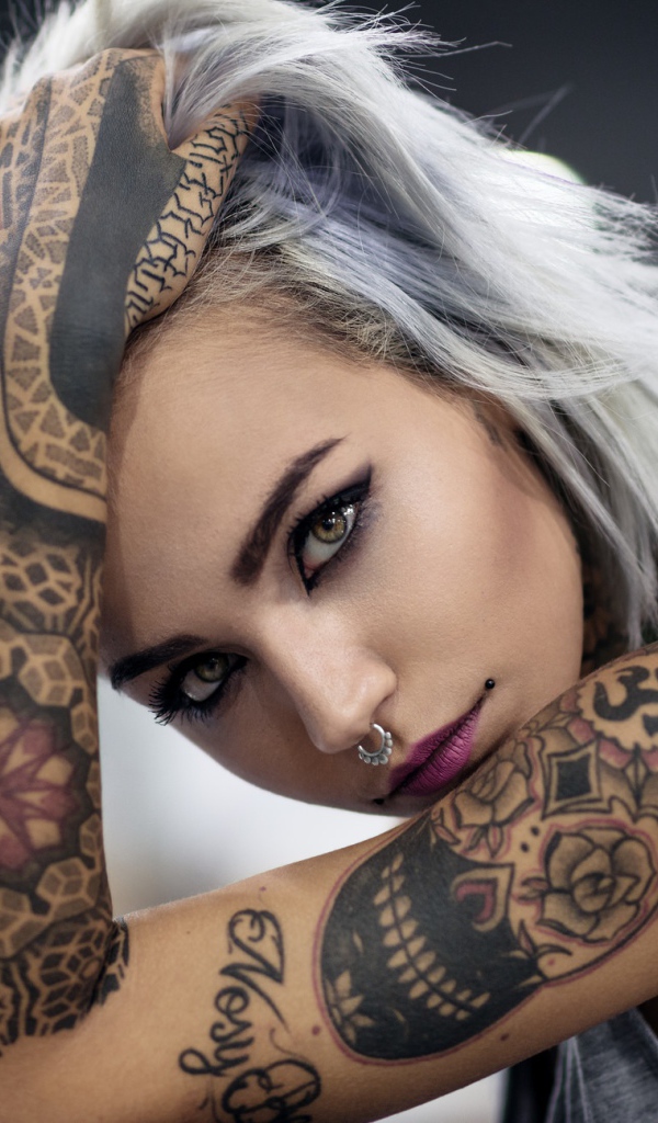 Молодая девушка с татуировками на теле 