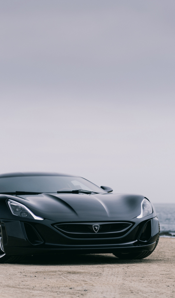 Черный спортивный автомобиль Rimac Concept One на фоне океана