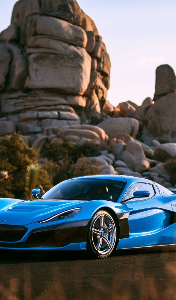 Голубой спортивный автомобиль  Rimac C_Two на фоне гор