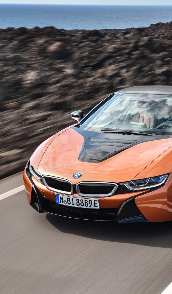 Оранжевый автомобиль BMW i8 Roadster, 2018 на скорости