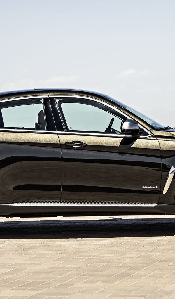 Черный автомобиль BMW X6, 2018 года вид сбоку