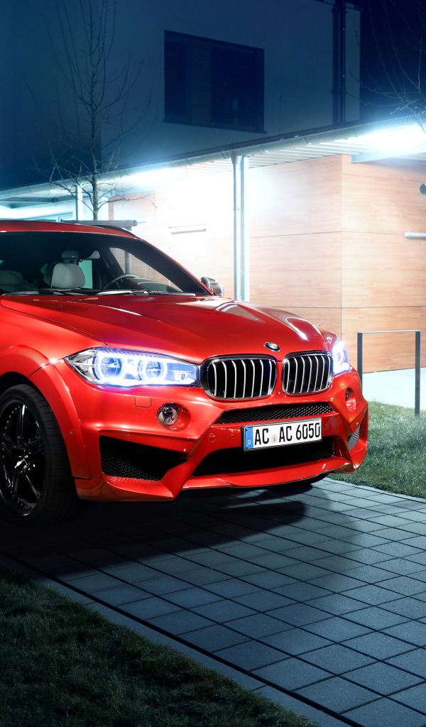 Красный автомобиль BMW X6 на тротуаре