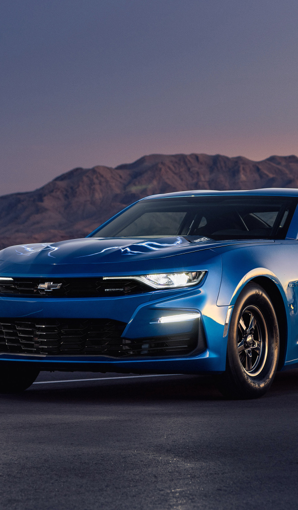 Синий автомобиль Chevrolet Camaro на трассе на фоне гор