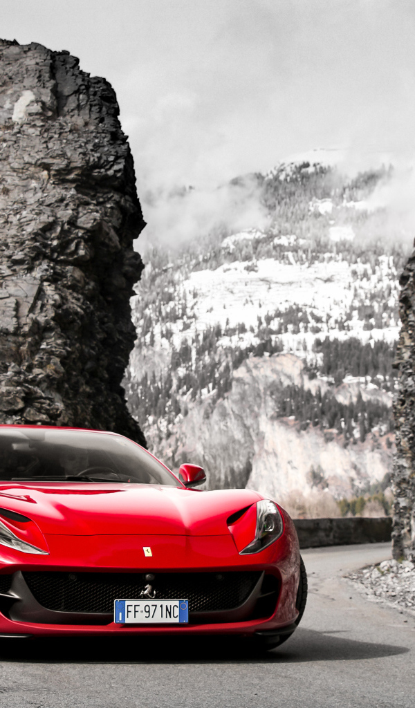 Красный спортивный автомобиль Ferrari Portofino 2018 года на фоне гор