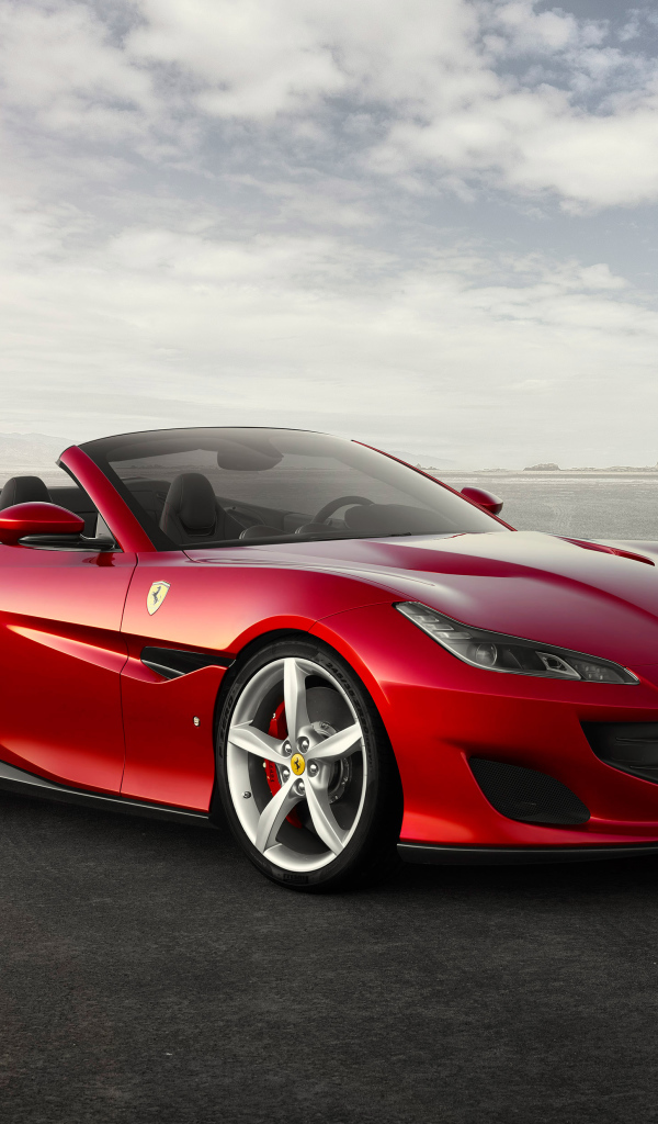 Красный автомобиль кабриолет Ferrari Portofino на фоне неба