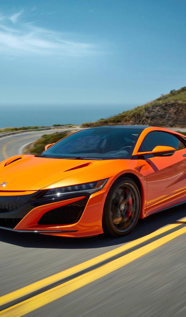 Оранжевый автомобиль Honda NSX на трассе под голубым небом