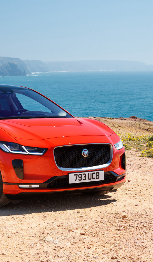 Красный Jaguar I-Pace EV400 AWD HSE First Edition 2018 года на фоне океана 