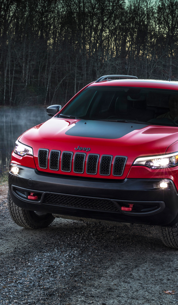 Красный автомобиль Jeep Cherokee Trailhawk, 2019 на дороге у реки