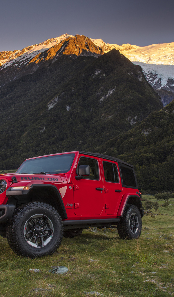 Красный автомобиль Jeep Wrangler на фоне гор