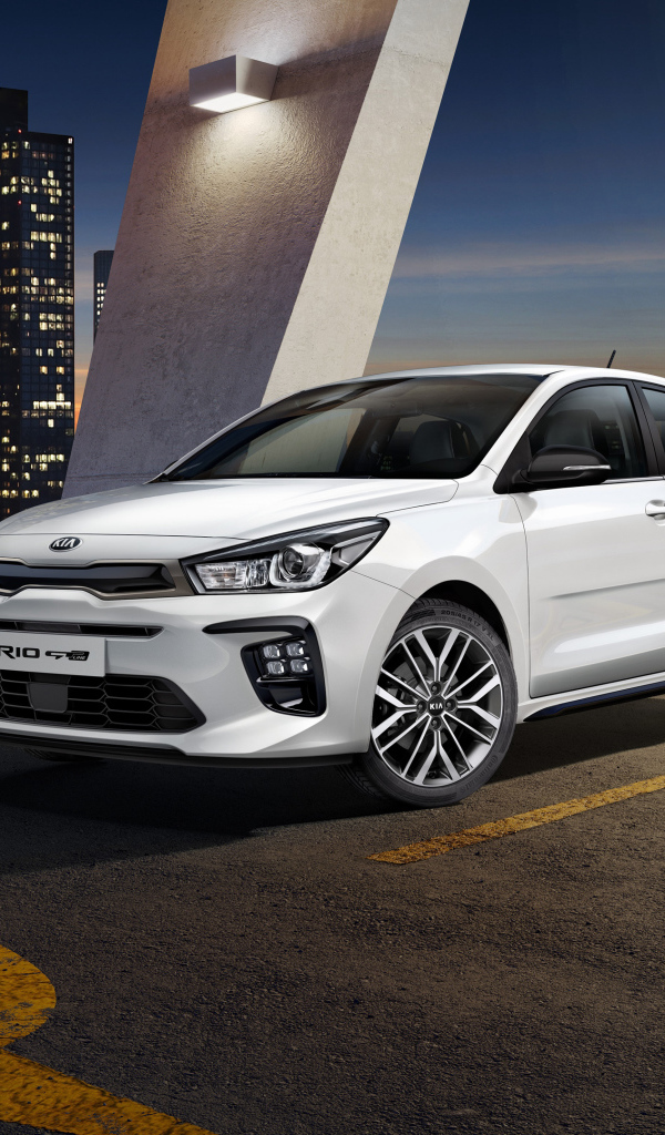 Белый автомобиль хэтчбек Kia Rio GT Line, 2018 на фоне ночного города