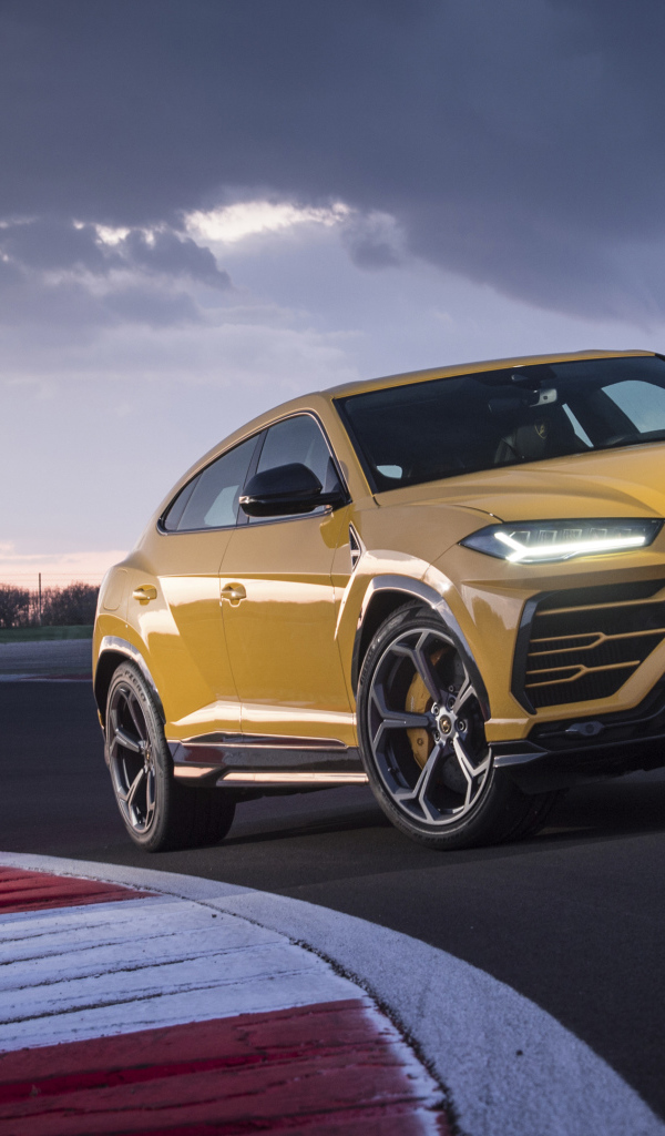 Желтый внедорожник Lamborghini Urus  едет по дороге