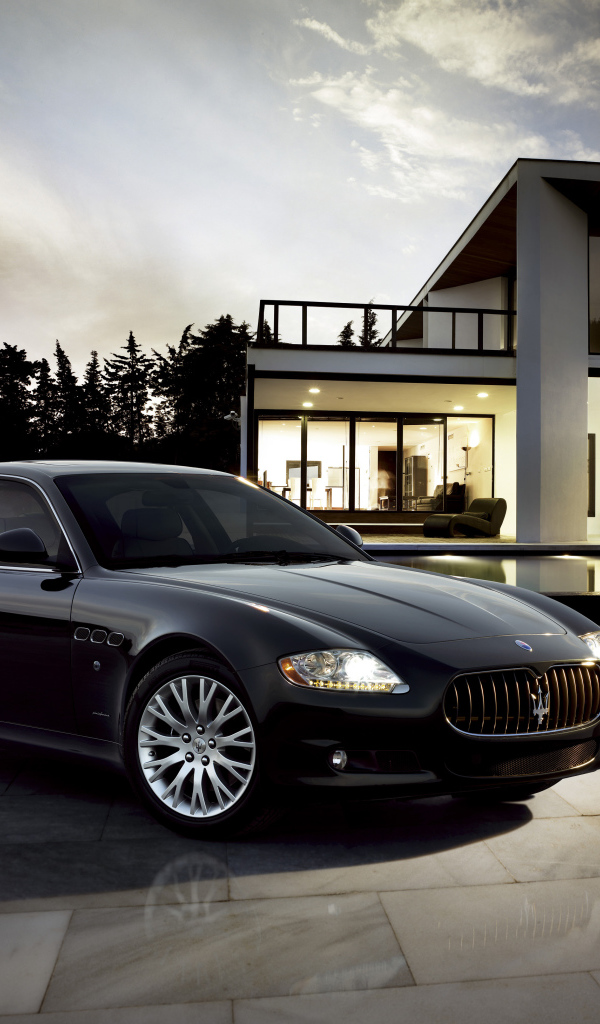 Черный автомобиль  Maserati Quattroporte у большого дома