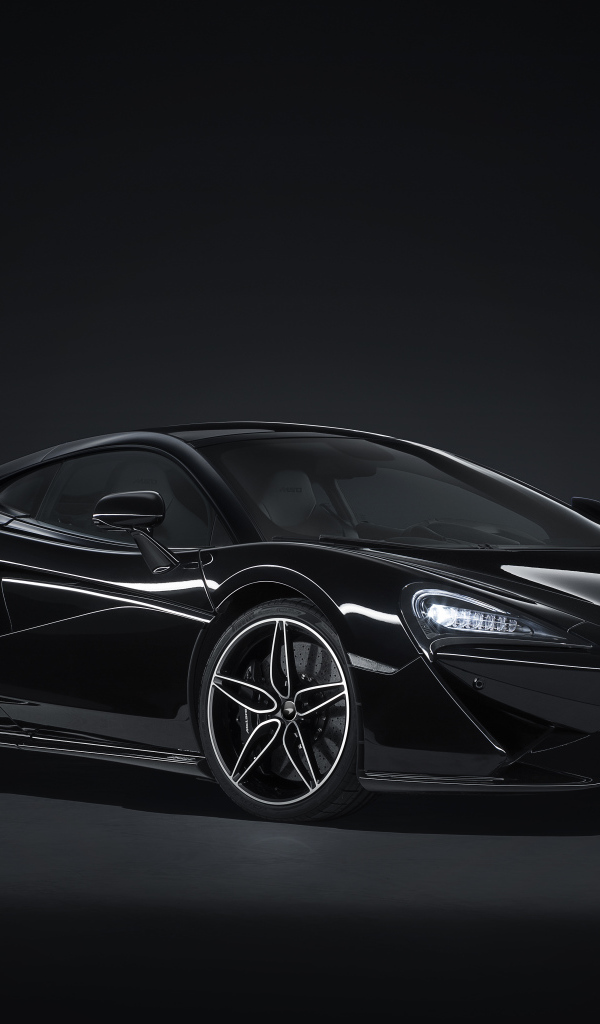 Черный автомобиль McLaren 570GT на сером фоне