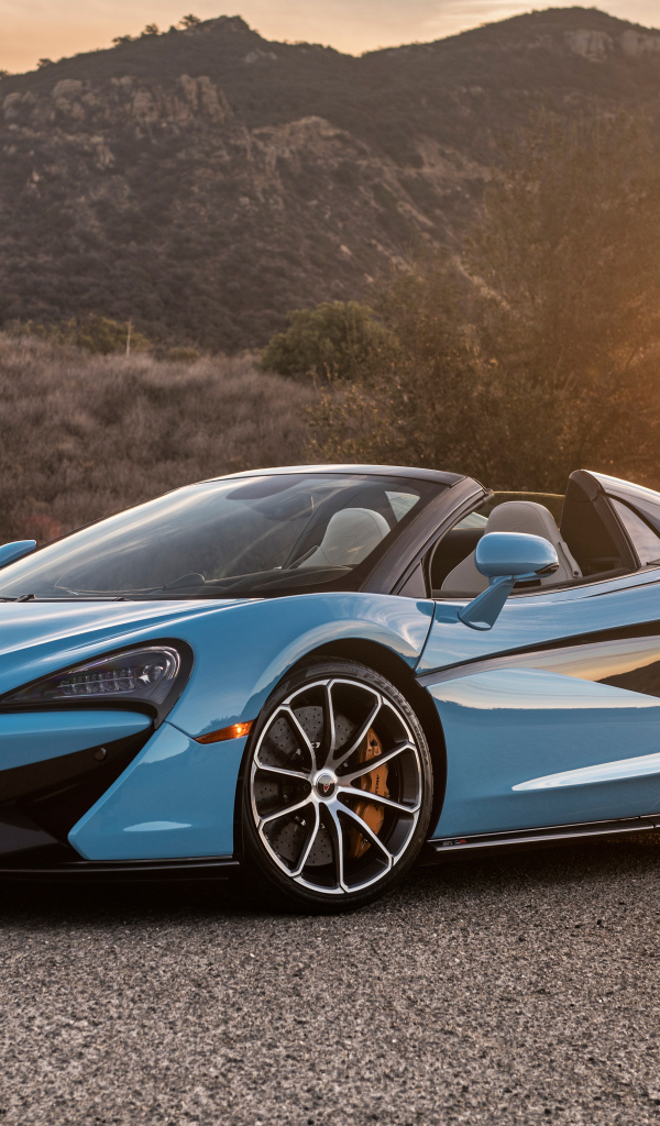 Blue sports car McLaren 570S Spider, 2018 on the background of the sun