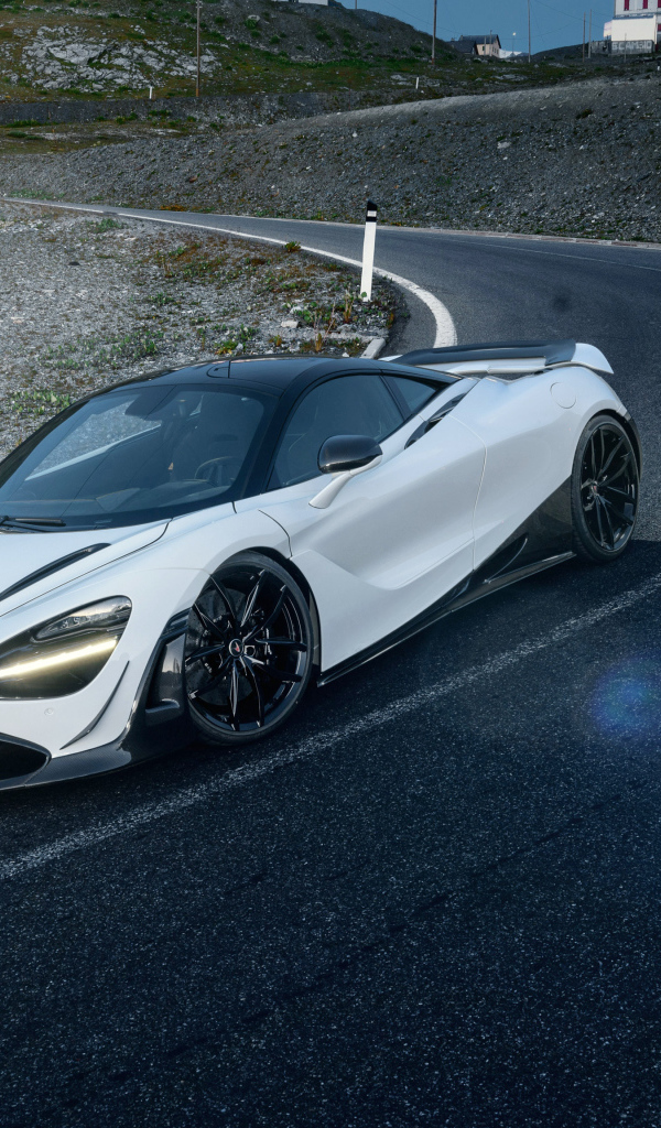 Белый спортивный автомобиль McLaren 720S, 2018 года на трассе