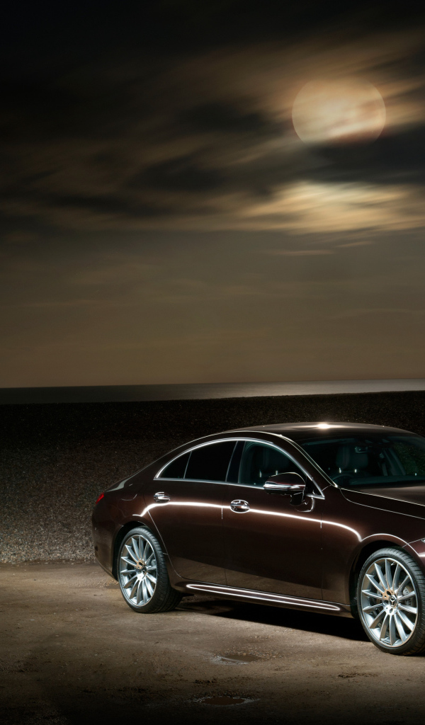 Коричневый автомобиль Mercedes Benz CLS 400 D AMG 2018 года на фоне луны