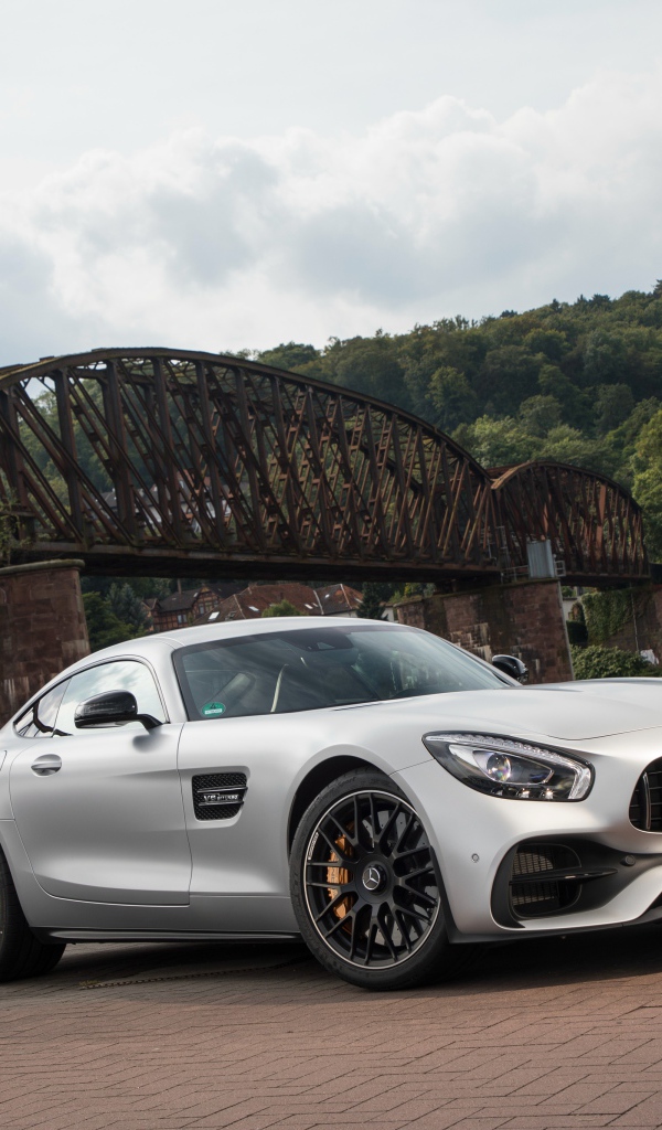 Серебристый автомобиль Mercedes-AMG GT на фоне моста