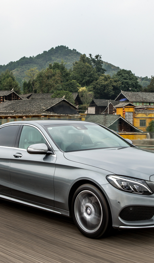 Серебристый автомобиль Mercedes-Benz C-Class на трассе