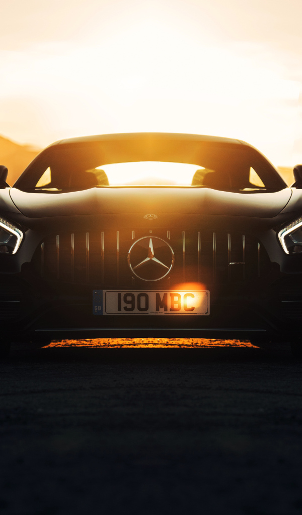 Стильный черный автомобиль Mercedes-AMG GT C на фоне заката