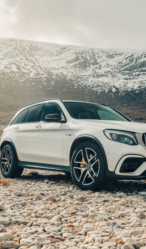 Белый внедорожник Mercedes AMG GLC 63 S, 2018 года на фоне гор