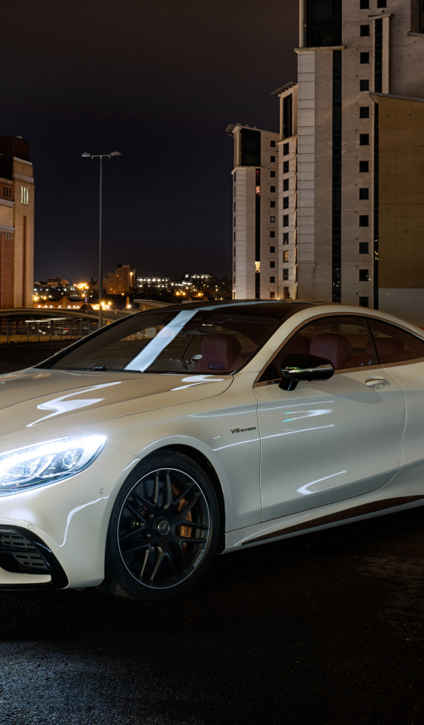 Белый автомобиль Mercedes AMG S 63 4MATIC Coupe, 2018 года на фоне города