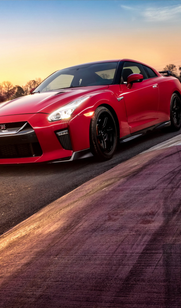 Красный автомобиль Nissan GT-R 2018 года на трассе на закате