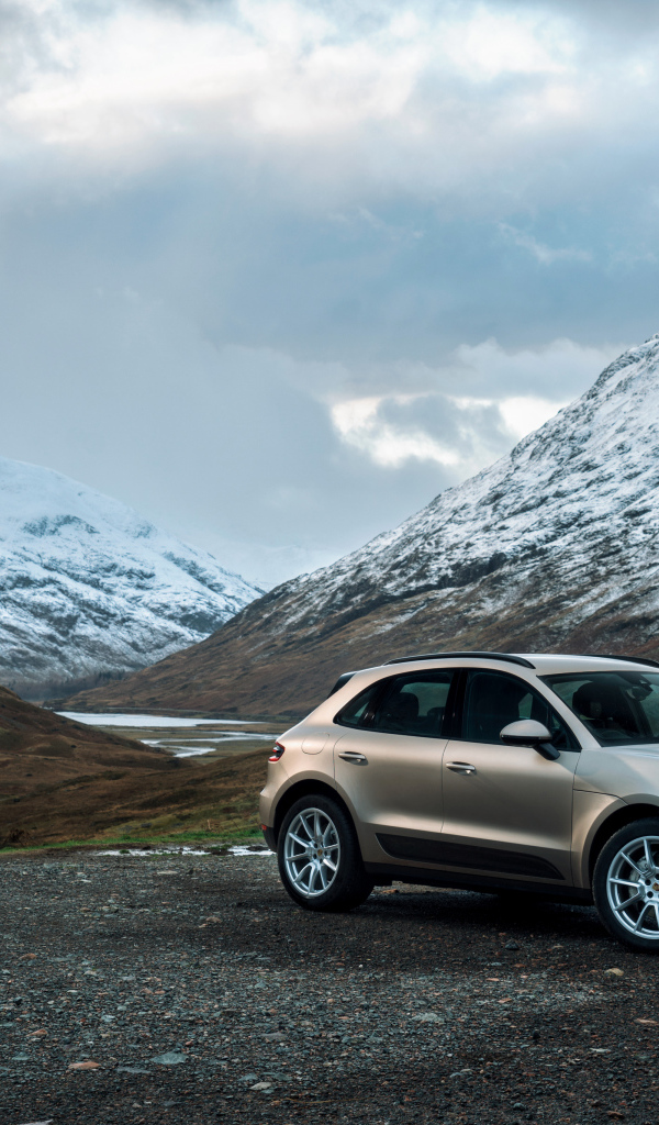 Внедорожник Porsche Macan на фоне заснеженных гор 