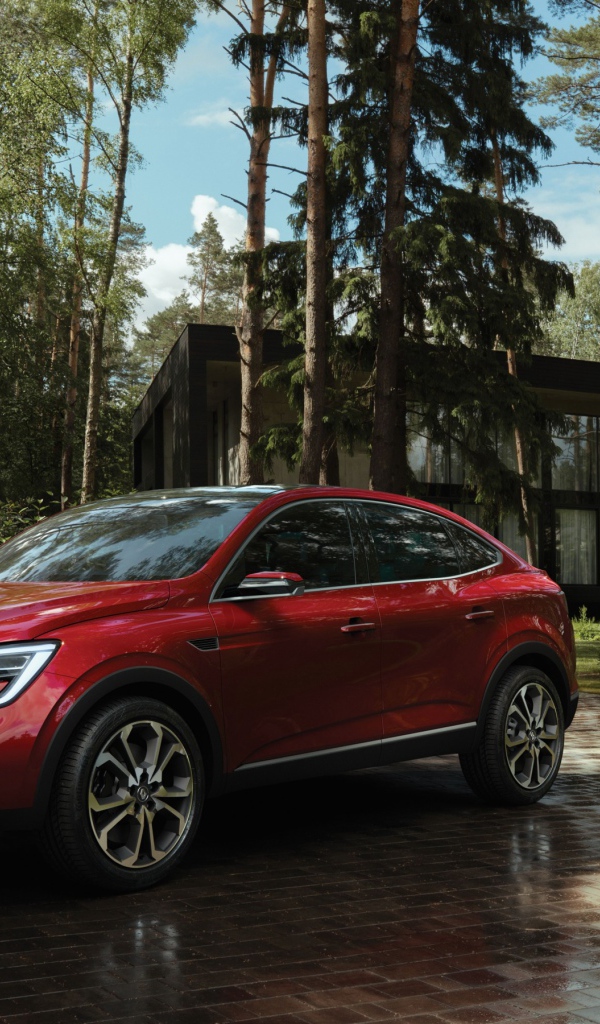 Red stylish SUV Renault Arkana, 2018 in the forest