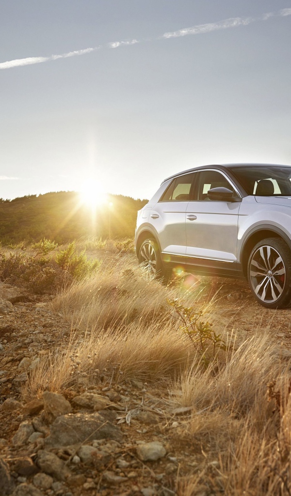 Серебристый внедорожник Volkswagen T-Roc, 2018 года на фоне солнца