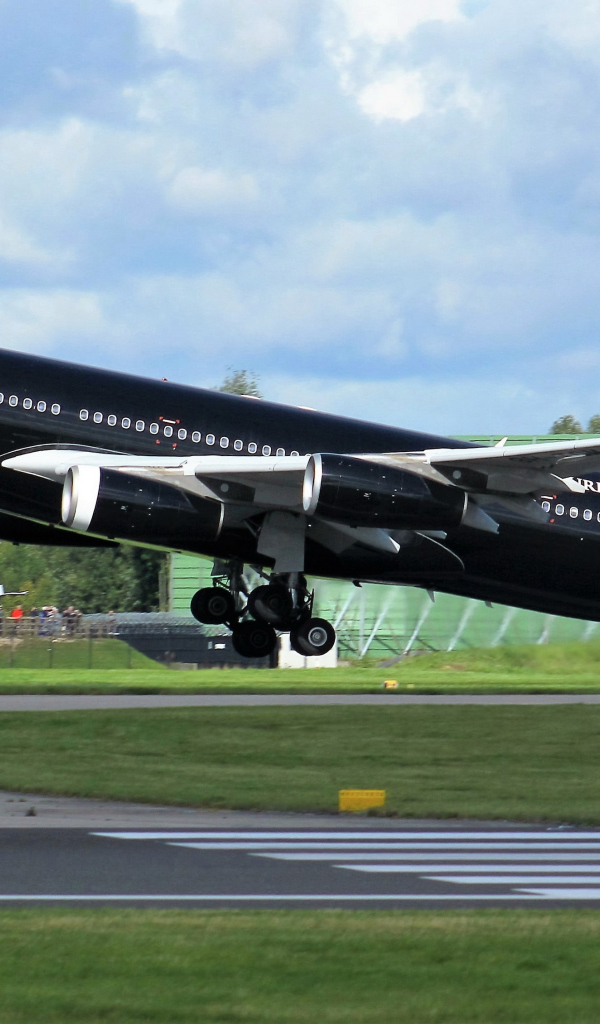 Черный пассажирский самолет Airbus A340-313 на взлете