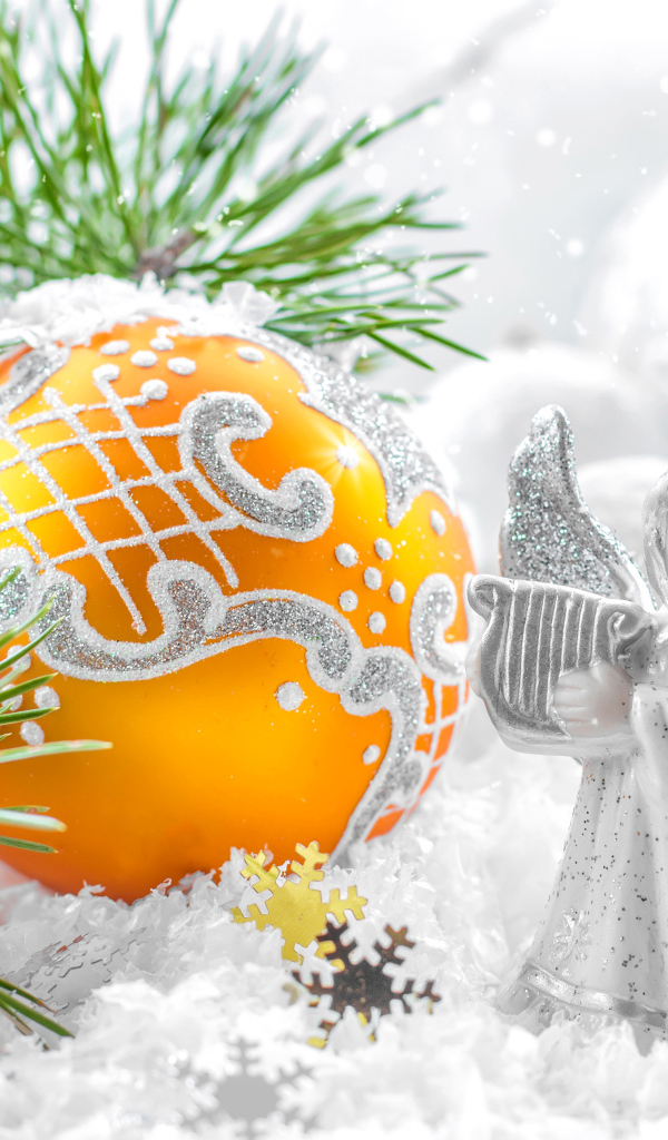 Рождественский ангел и елочная игрушка на снегу 