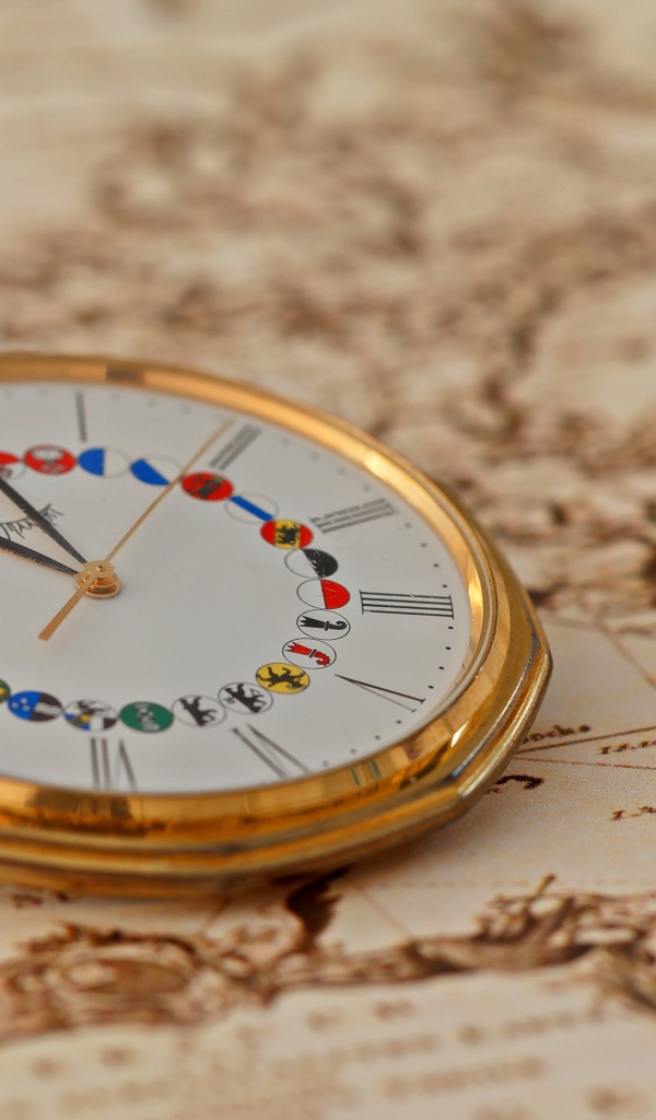 Карманные часы в золотой оправе лежат на карте