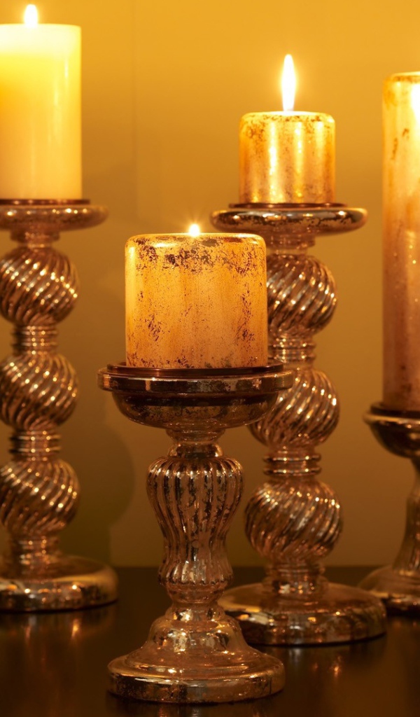 Старинные подсвечники с зажженными свечами на столе 