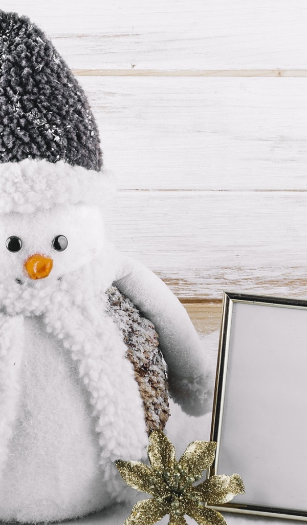 Big toy snowman on a wooden background