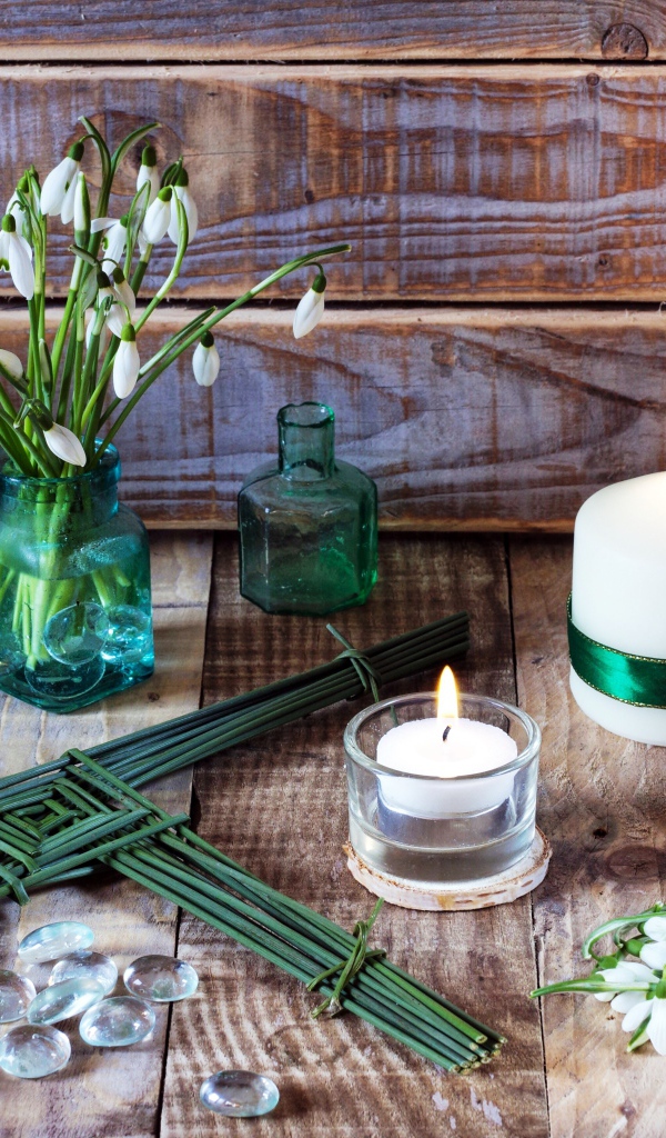 Букет подснежников на столе с зажженными свечами