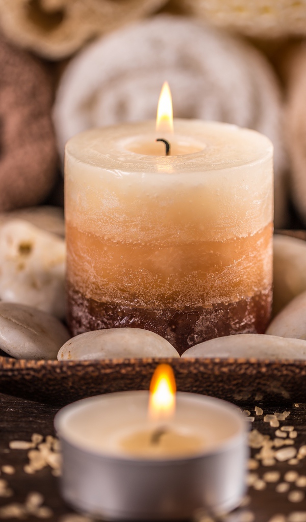 Зажженная свеча с камнями для SPA процедур