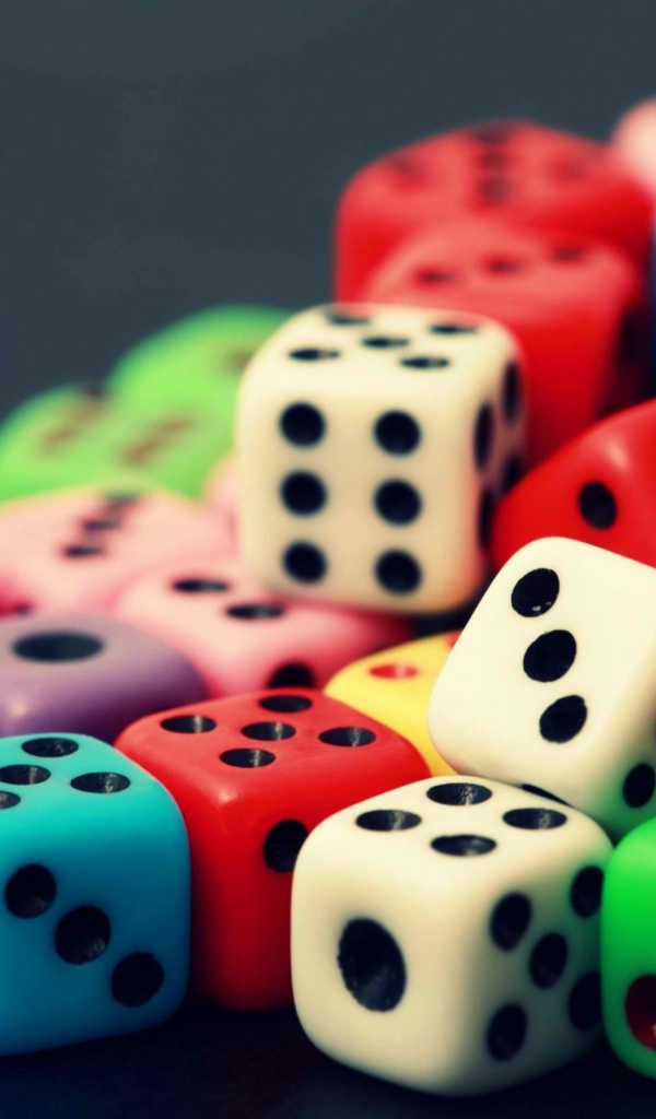 Разноцветные игральные кости на сером столе 