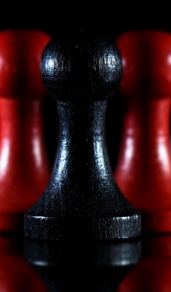Красные и черные шахматные фигуры на черном фоне