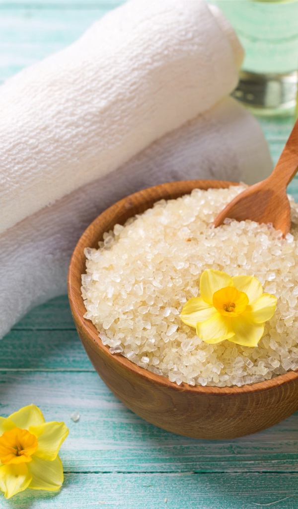 Соль с цветами нарцисса и полотенцем на столе