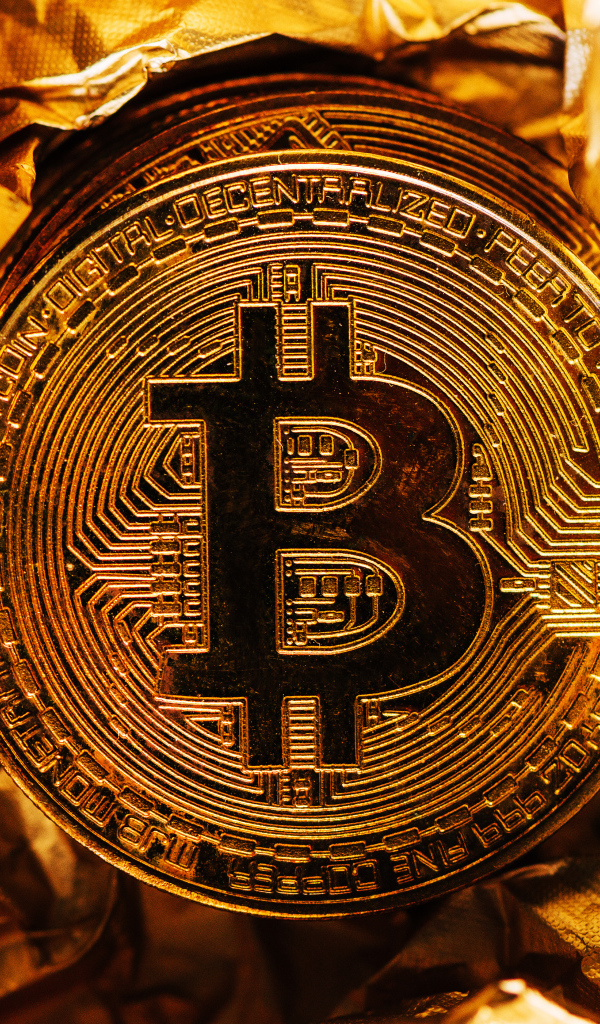 Золотая монета биткоин на фольге
