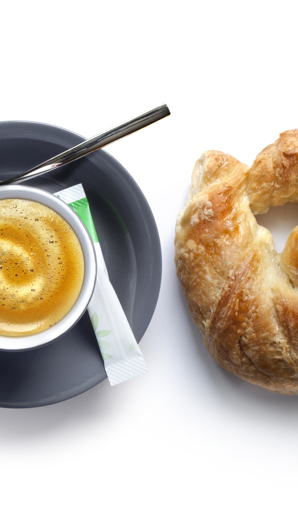 Круассан и чашка кофе на белом фоне