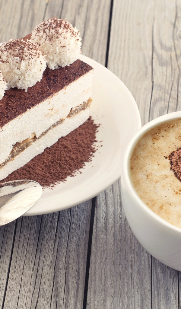 Чашка капучино с пирожным на столе 