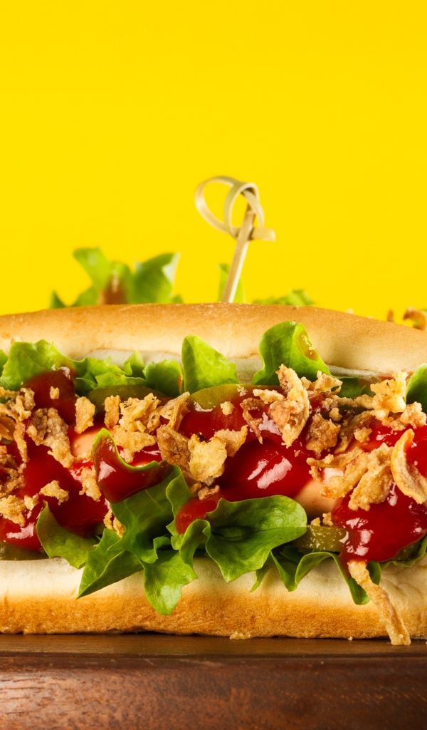 Аппетитные хотдоги на желтом фоне крупным планом