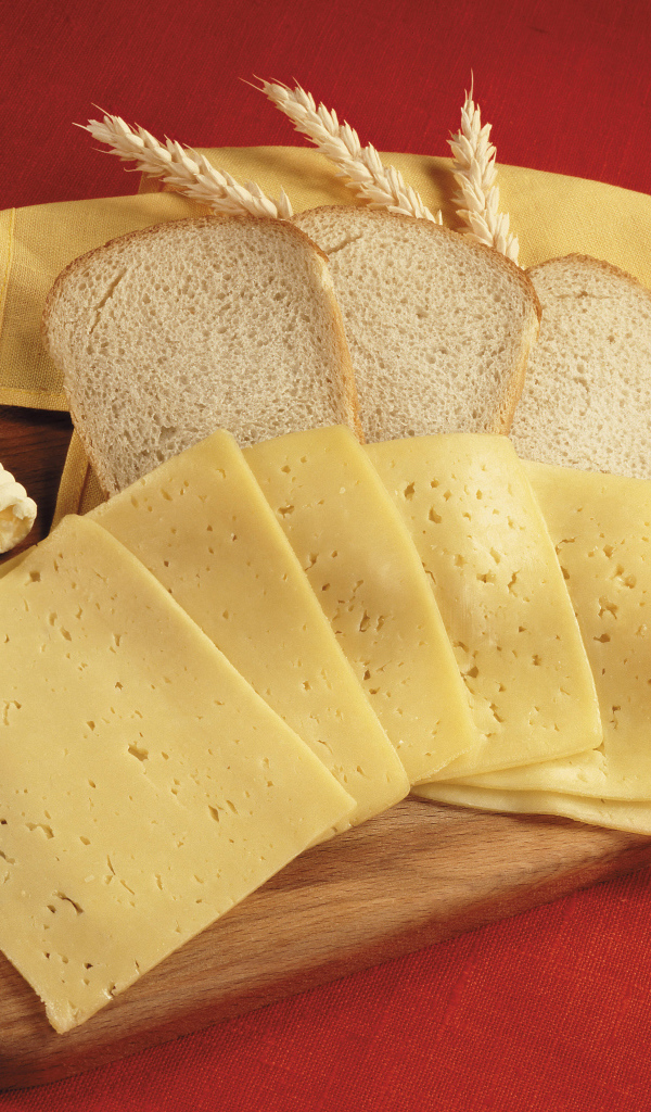 Хлеб с кусками сыра на разделочной доске