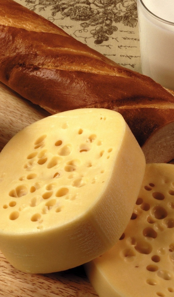 Сыр на столе с маслом, молоком и батоном 
