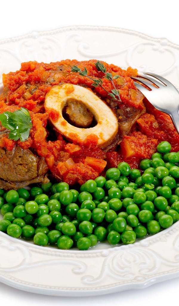 Зеленый горошек на белой тарелке с мясом