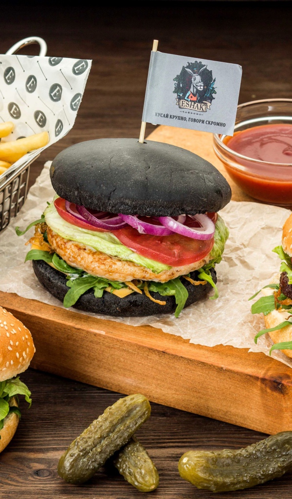 Гамбургеры с картофелем фри и солеными огурцами на столе 