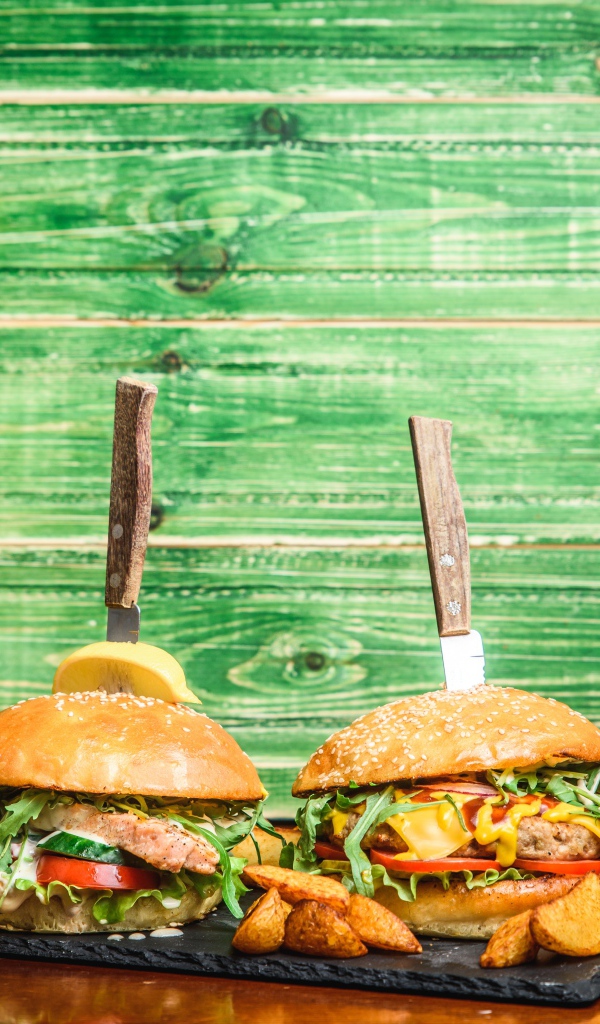 Гамбургеры с ножами на деревянном фоне