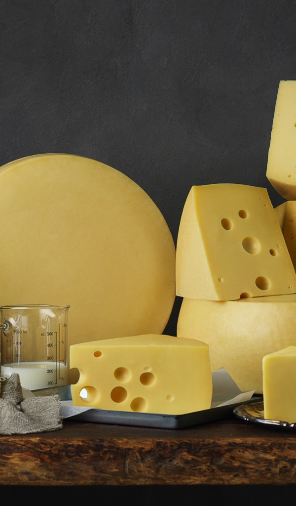 Твердый сыр на столе с книгами 