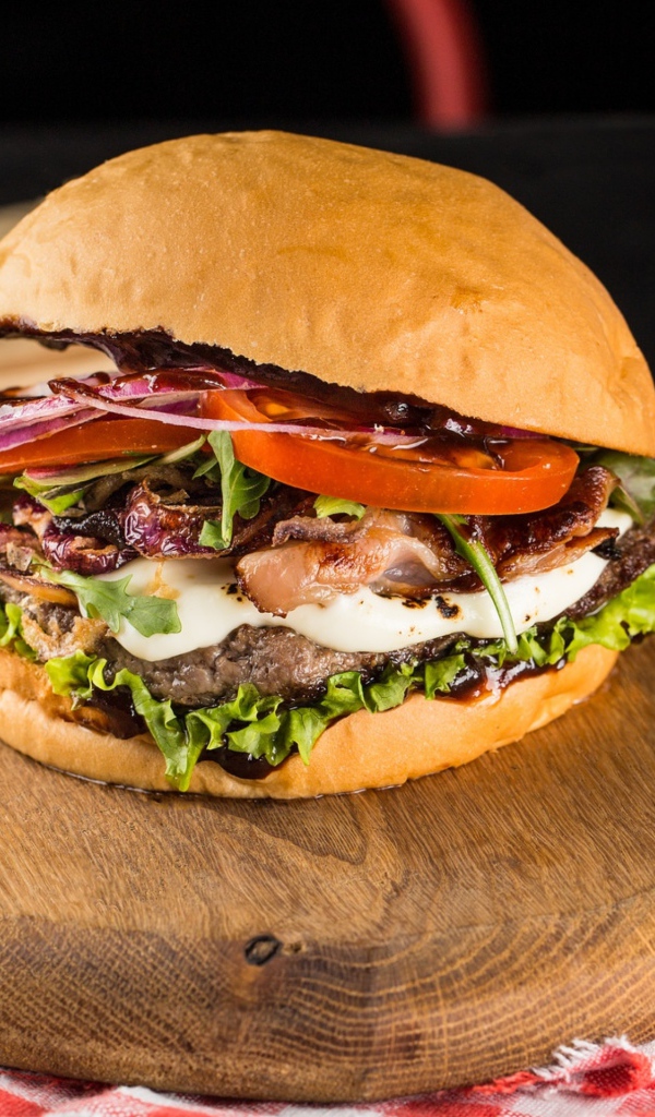 Большой аппетитный гамбургер на деревянной доске 